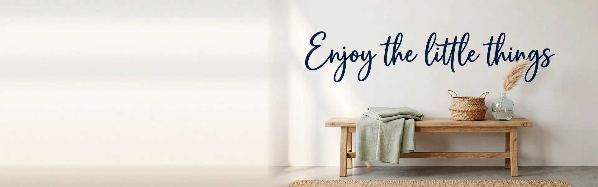 Scritta «Enjoy the little things» in vinile blu navy sopra una panca di legno